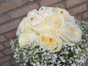 Ein wunderschöner Strauß aus weißen Rosen mit zarten Blüten und funkelnden Akzenten.