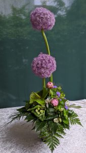 Ein wunderschöner Blumenstrauß mit lila Allium und bunten Blumen in einer eleganten Anordnung.