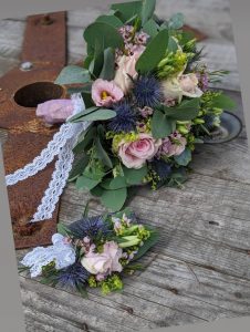 Ein wunderschöner Blumenstrauß mit Rosen und Eukalyptus auf rustikalem Holz.