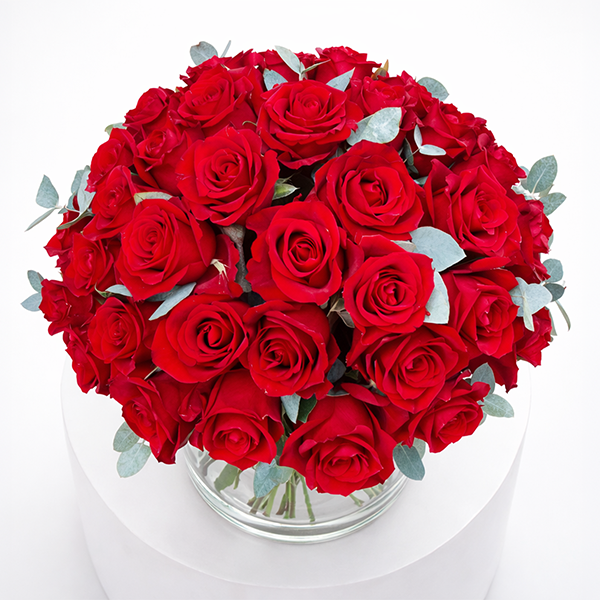 Wunderschöner Strauß aus roten Rosen in einer Glasvase, perfekt als romantisches Geschenk für deine Liebsten.